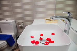 Un baño con lavamanos, inodoro y bidé blancos.