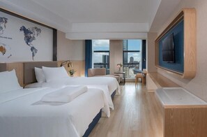 A hotel room with two beds, a TV, a world map, and a city view. - Kyriad Marvelous Hotel Huizhou Huiyang Station YI Center (Huizhou)