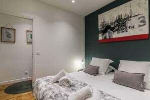 A bedroom with a bed, pillows, a wall art piece, and a door. - Charming Apartment - 2ch/6p - Montreuil (Montreuil)