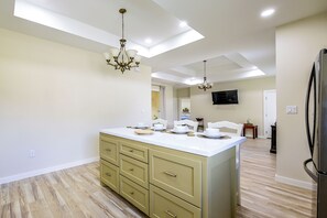 A modern kitchen with a central island, built-in cabinetry, and a chandelier. - Single Home: SpaceX, Hwy 511 & Beaches (Brownsville)