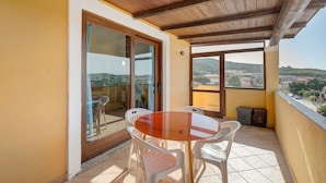 Un balcon avec une table et des chaises, une vue sur la ville et un plafond en bois.
