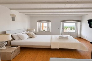 Una camera da letto con un letto grande, un comodino, una lampada e una finestra vista.