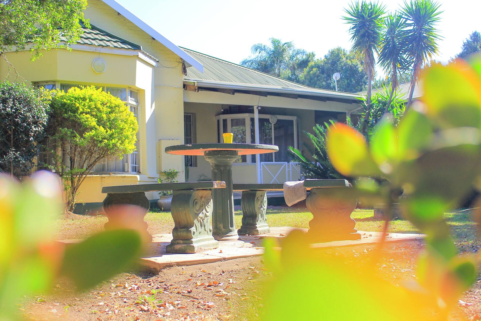 A building with a porch and a fountain in the foreground.