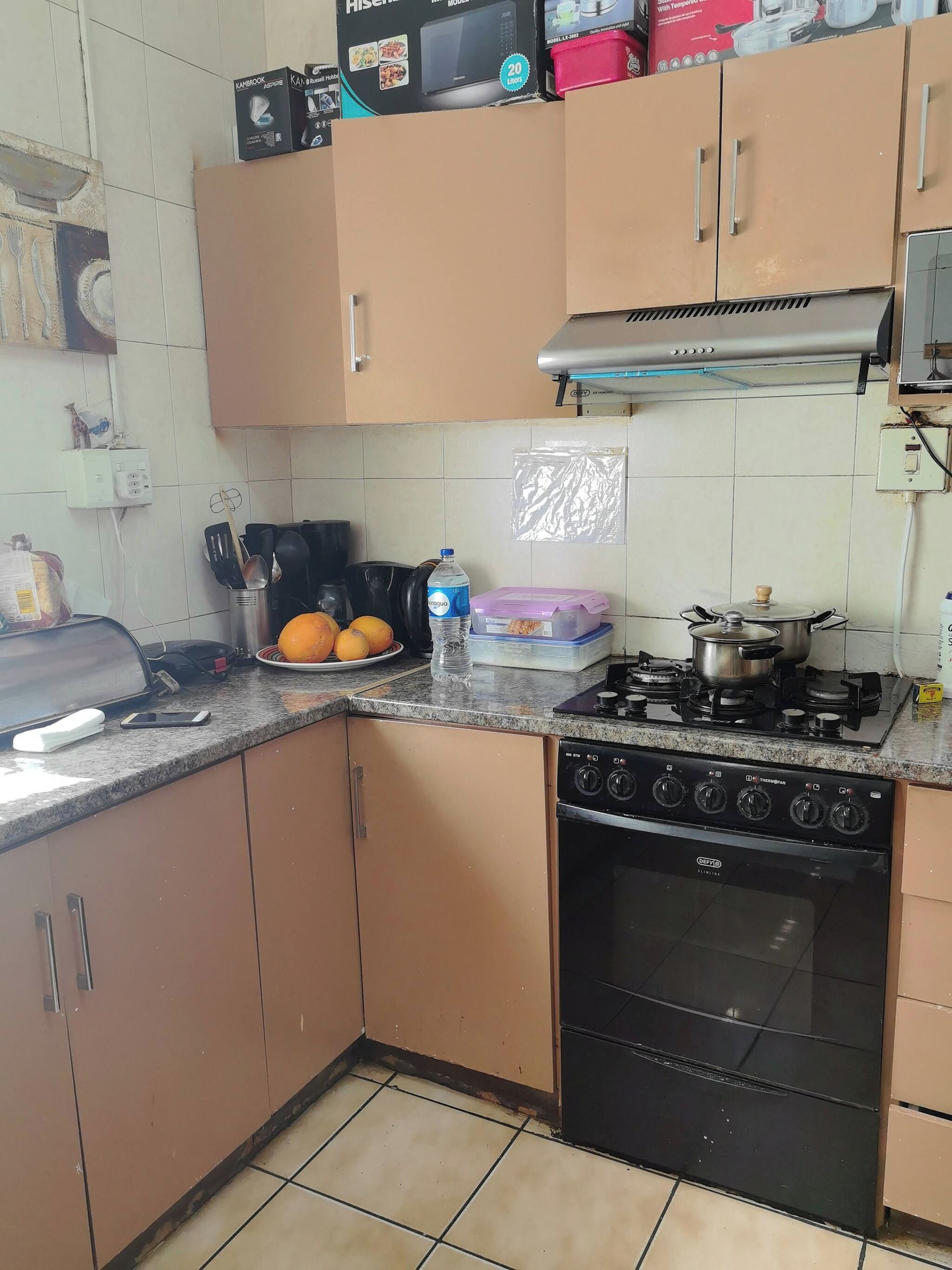 A kitchen with a gas stove, oven, and a microwave on the countertop.