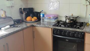 A kitchen with a gas stove, oven, and a microwave on the countertop.