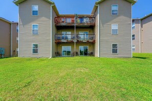 A two-story building with a flat roof, a covered patio area, and a grassy front yard. - Perfect Location! Amazing Views & Close to It All! (Branson)