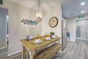 A dining area with a wooden table, chairs, a chandelier, wall art, a clock, and a refrigerator. - Perfect Location! Amazing Views & Close to It All! (Branson)