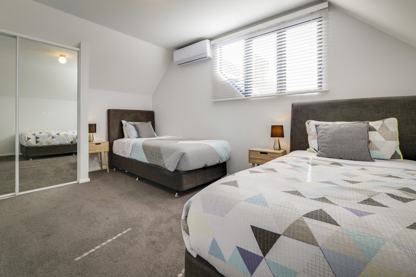 Una camera da letto con un letto, comodini, un armadio e un condizionatore.