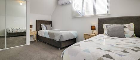 Una camera da letto con un letto, comodini, un armadio e un condizionatore.
