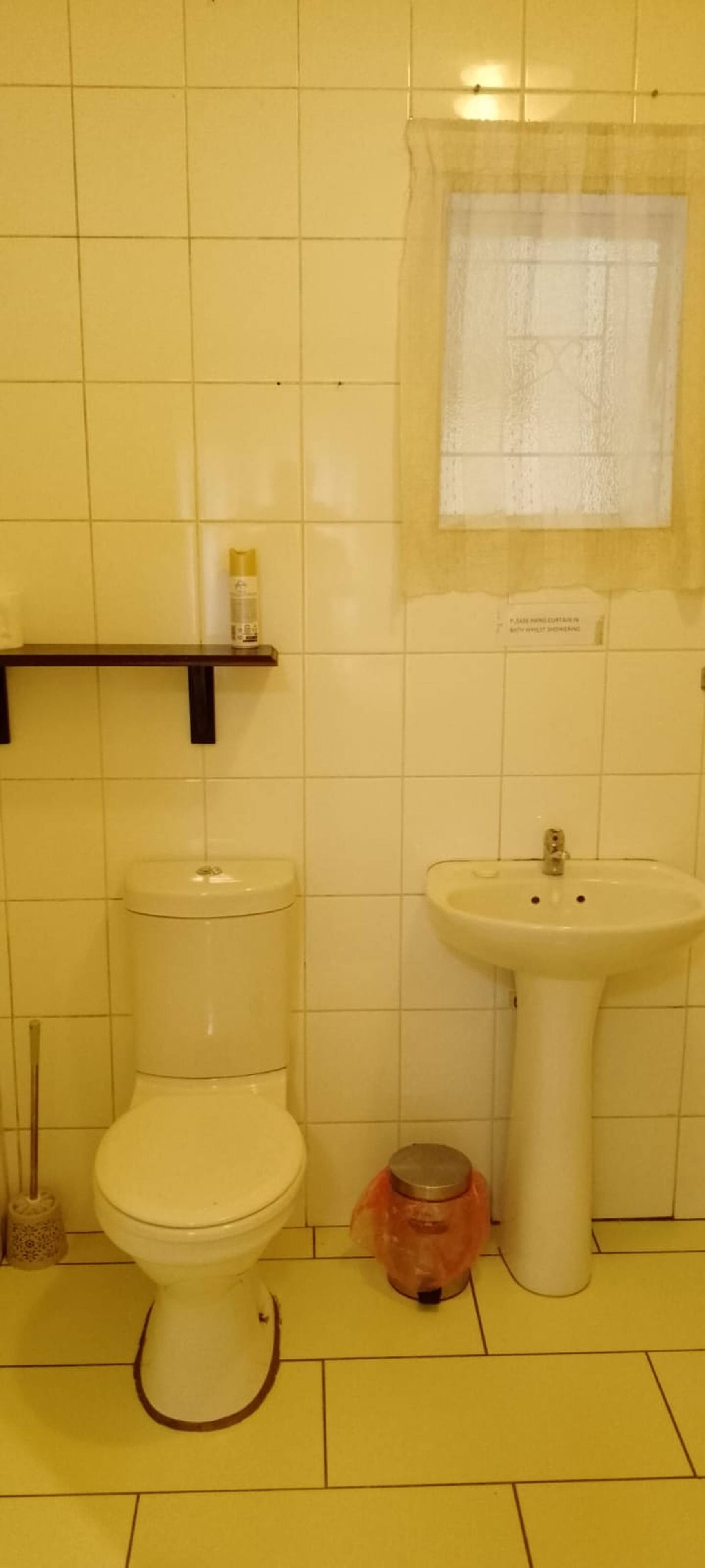 A bathroom with a toilet, a sink, and a shower curtain.