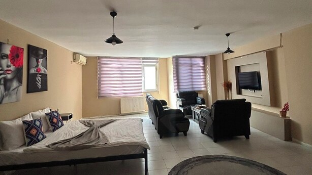 Ein geräumiges Wohnzimmer mit einem großen Bett, einem Sofa, einem Couchtisch und einem Fernseher.