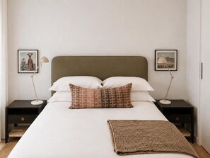 A neatly made bed with a white duvet, two pillows, a brown throw blanket, and two bedside tables with lamps. - Luxury One-Bedroom with Balcony -Unit 9 (Stellenbosch)