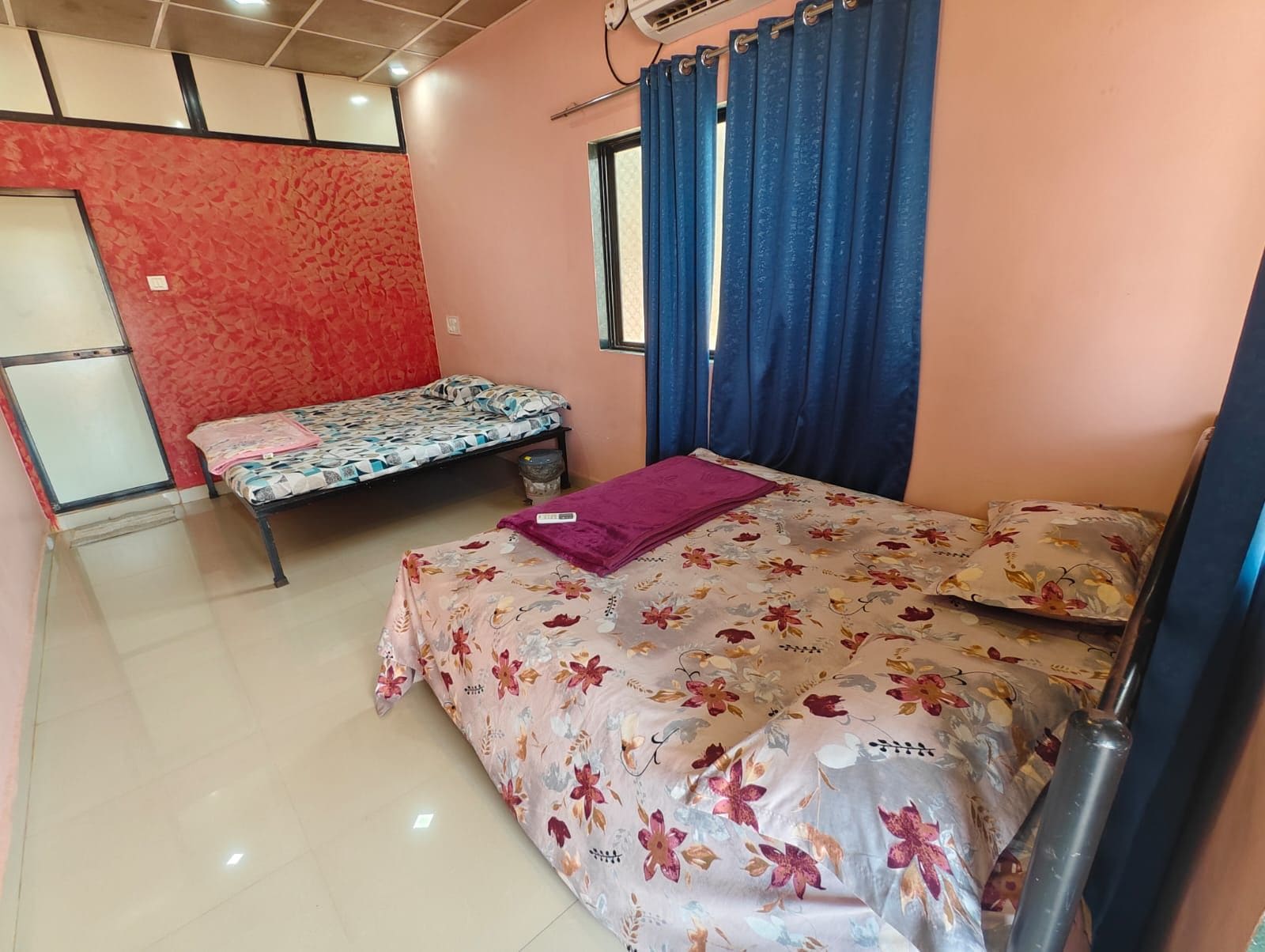 Un dormitorio con dos camas, una con colcha estampada y la otra con diseño.