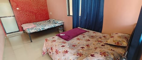 Un dormitorio con dos camas, una con colcha estampada y la otra con diseño.