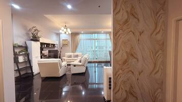 A modern living room with a sofa, a television, and a decorative plant.