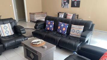 Ein Wohnzimmer mit einem schwarzen Ledersofa, einem Couchtisch und dekorativen Kissen.