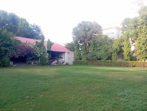 A building with a red roof, surrounded by greenery and a well-maintained lawn.