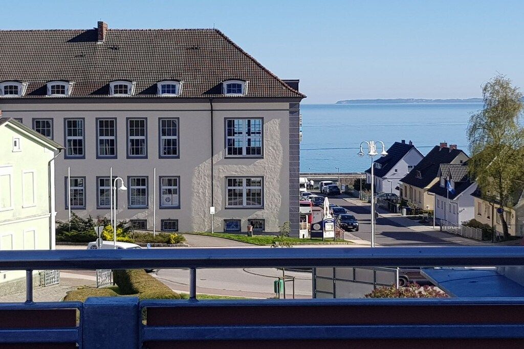 A residential building with a tiled roof, multiple windows, and a view of the sea.