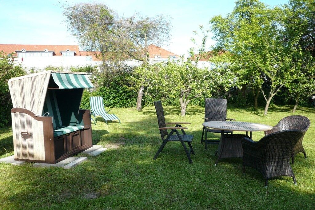 An outdoor seating area with a grill, chairs, and a table.