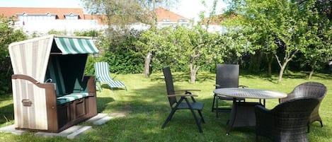 An outdoor seating area with a grill, chairs, and a table.