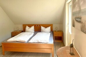 Ein Schlafzimmer mit einem hölzernen Bett, zwei Nachttischen und einem Bild an der Wand.