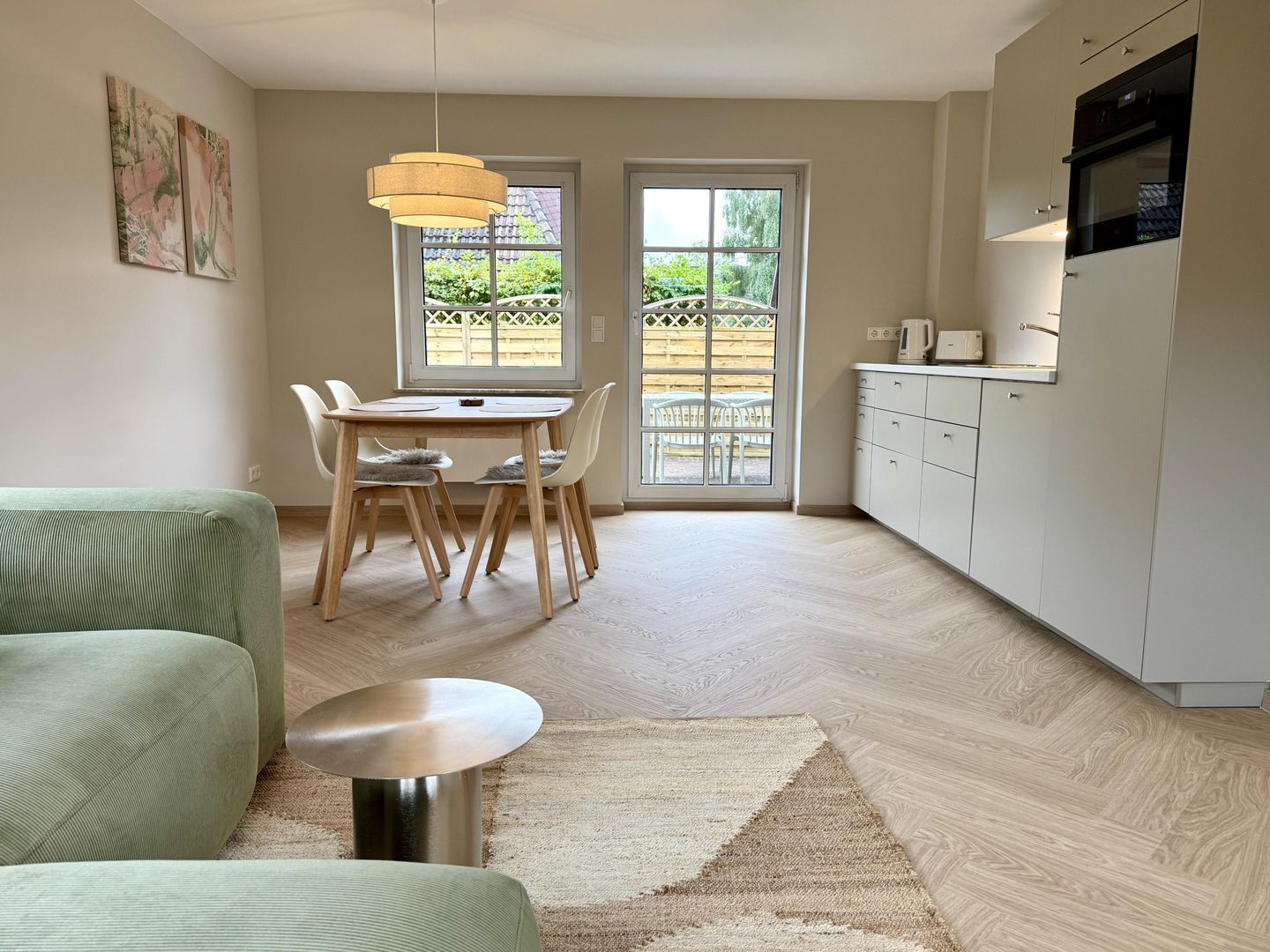 A modern kitchen with a dining area, a sofa, and a coffee table.