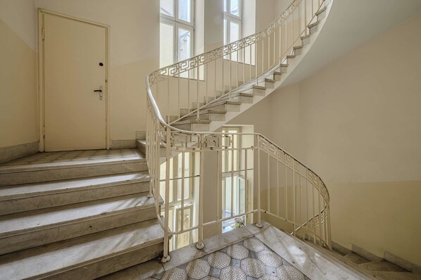 A spiral staircase with a metal railing, leading to an upper floor.