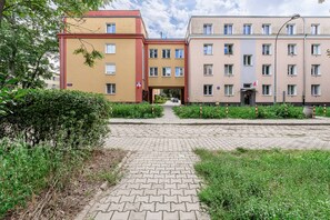 Ein mehrstöckiges Wohngebäude mit einem gepflasterten Weg zum Eingang.