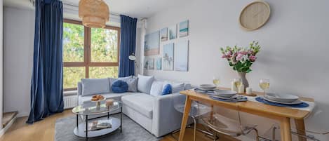Una sala de estar moderna con un sofá, una mesa de centro y una mesa de comedor.