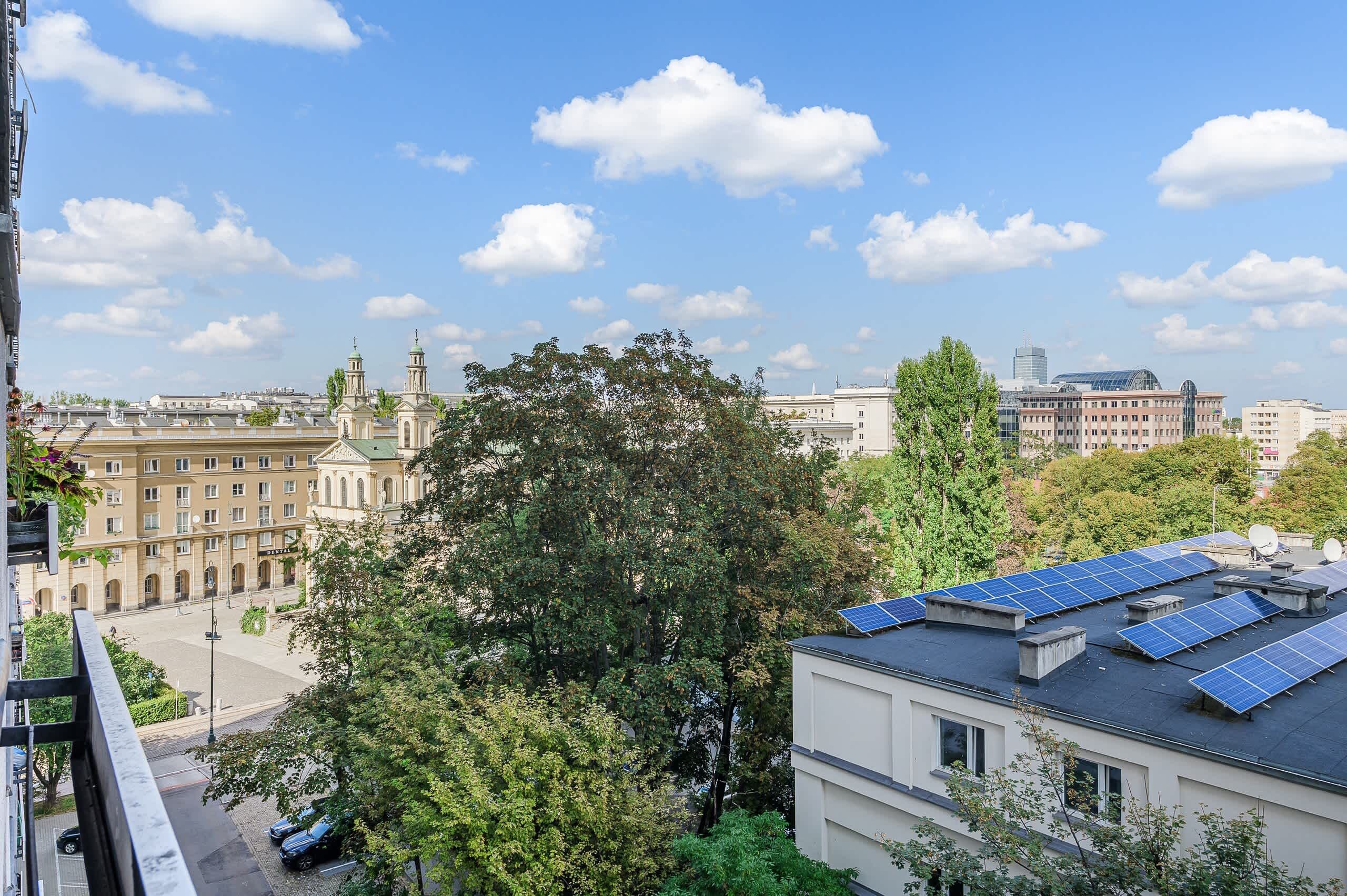 A cityscape with historical buildings, a modern skyscraper, and solar panels on a residential building.