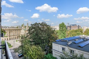 Eine Stadtansicht mit historischen Gebäuden, einem modernen Wolkenkratzer und Solaranlagen an einem Wohnhaus.