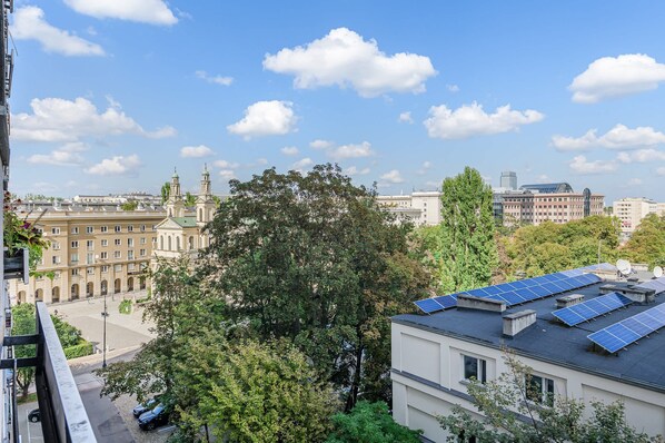 Paisagem urbana com edifícios históricos, um arranha-céu moderno e painéis solares em um prédio residencial.