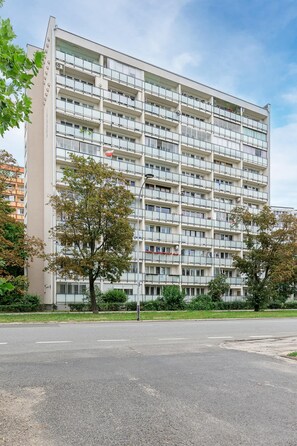 A multi-story residential building with balconies, a flat facade, and a clear sky. - Lumina 3-room Apart w/ Balcony near ZOO (Warszawa)