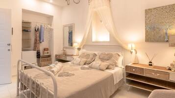 A bedroom with a bed, bedside tables, a wardrobe, and a chandelier.