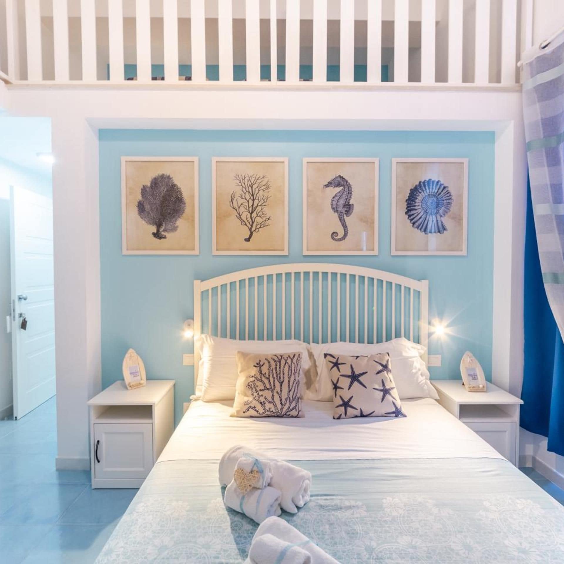 A bedroom with a bed, nightstands, and wall art.