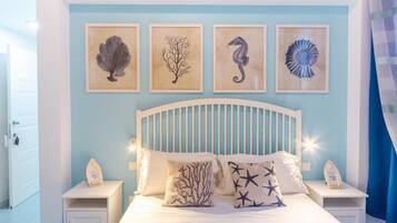 A bedroom with a bed, nightstands, and wall art.