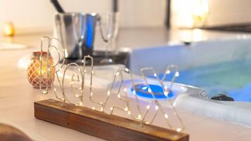 A wooden stand with a wireframe design, possibly a decorative piece, in a room with a bathtub and a metal container in the background.