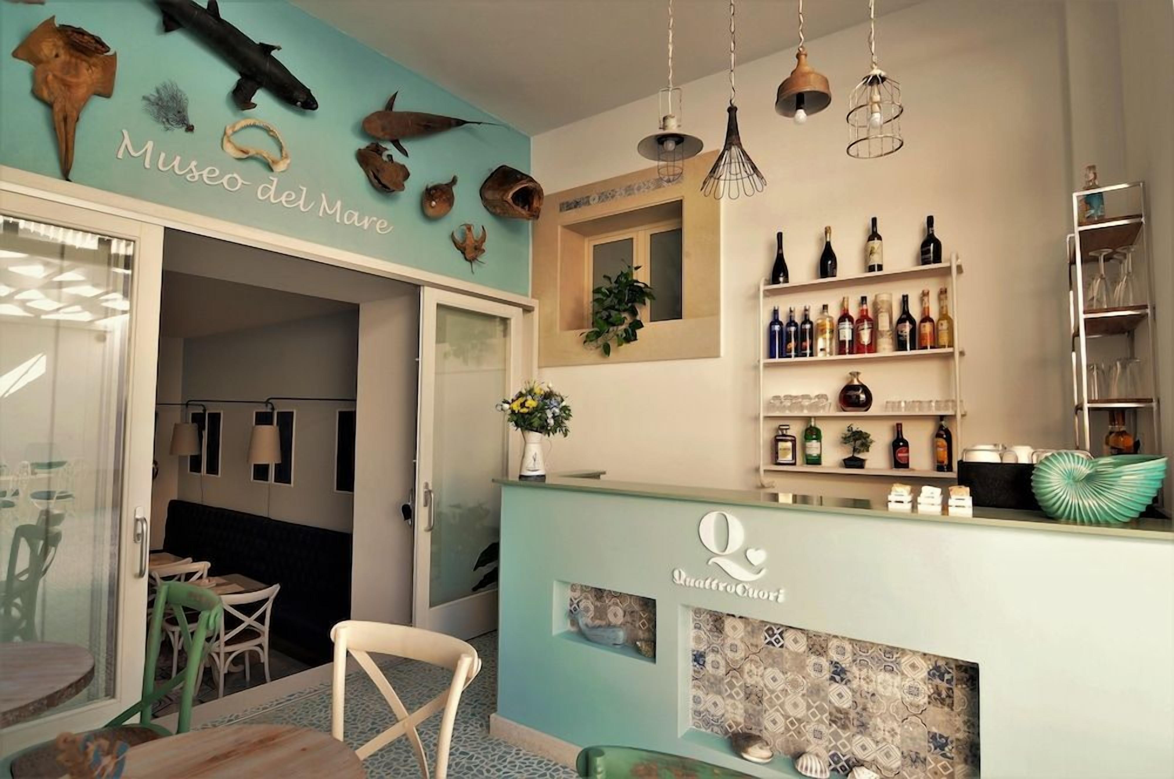 A bar area with a counter, shelves of bottles, and a wall with marine-themed decorations.