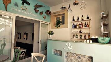 A bar area with a counter, shelves of bottles, and a wall with marine-themed decorations.