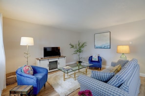 A living room with a sofa, armchair, coffee table, and a flat-screen TV. - Cozy Condo 6 Mi to Downtown Reno! (Reno)