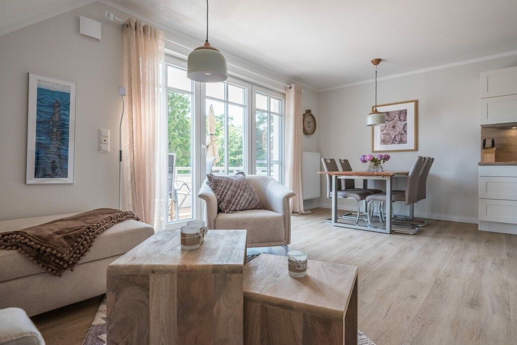 A modern living room with a sofa, a wooden coffee table, and a dining area with a table and chairs.