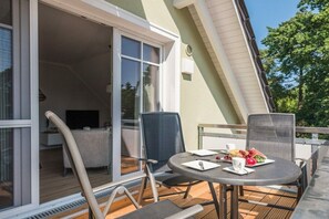 A balcony with a table, chairs, and a dining setup. - Holiday apartment with 1 bedroom (Prerow)