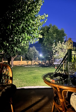 An outdoor seating area with a table and chairs, a grassy lawn, and trees. - Holiday Home '3 Bedrooms House' with Mountain View, Wi-Fi and Air Conditioning (Νέο Σαλμένικο)