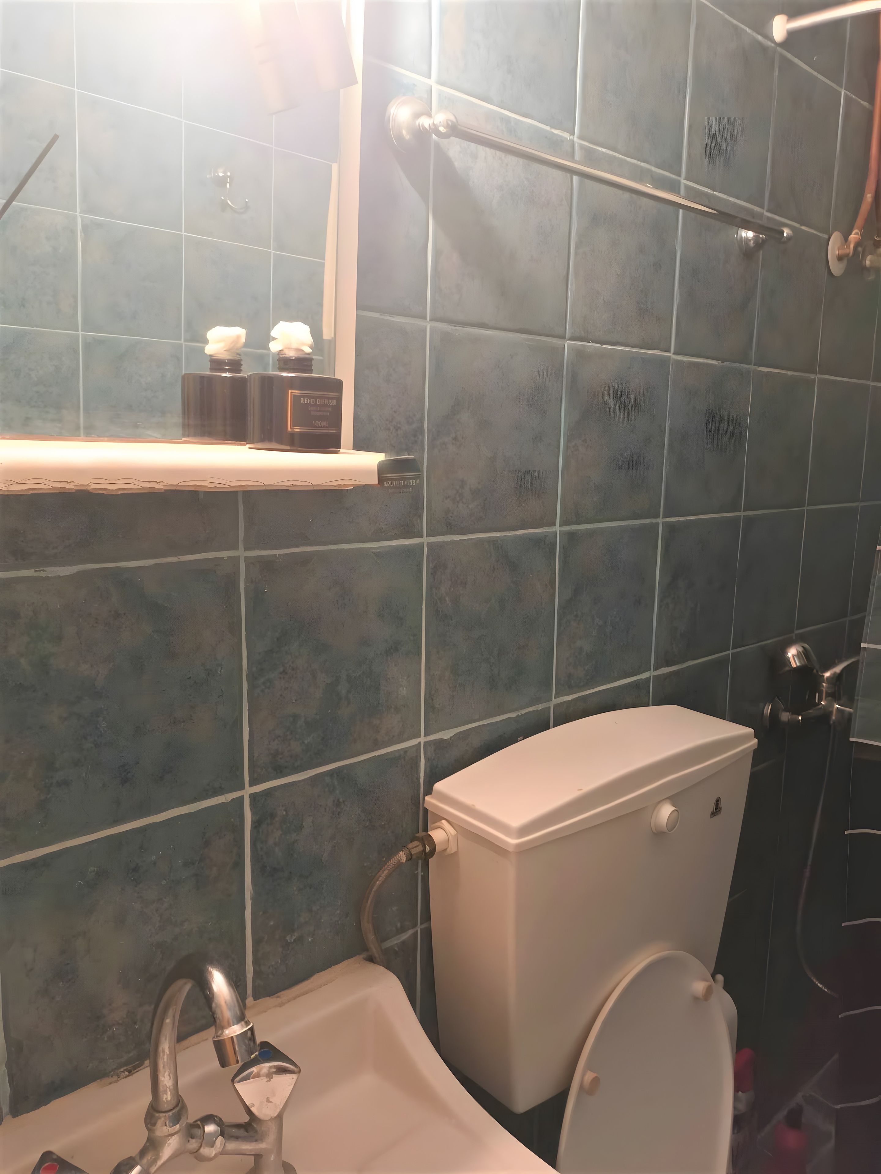 A bathroom with a toilet, sink, and shower area.