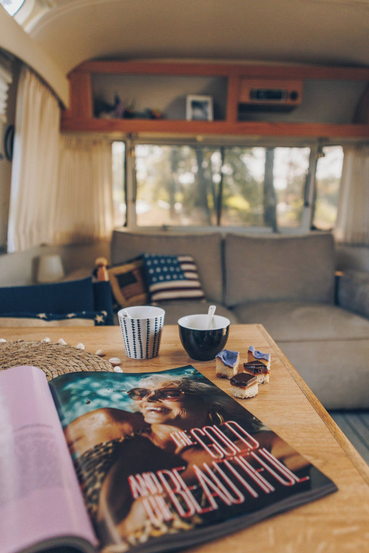 Un espace intérieur chaleureux avec une table en bois, un magazine, une tasse et un bol.