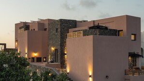 A modern building with a flat roof, multiple levels, and a stone facade. - Where luxury meets the magic of Santorini, with a private pool and private spa! (Kamari)