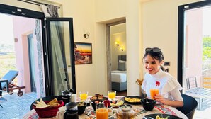 A breakfast setting with a table, breakfast items, and a view of the outdoors. - Where luxury meets the magic of Santorini, with a private pool and private spa! (Kamari)