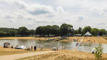 Un parc au bord du lac, avec des zones de sable, une rampe pour bateaux et un petit bâtiment.