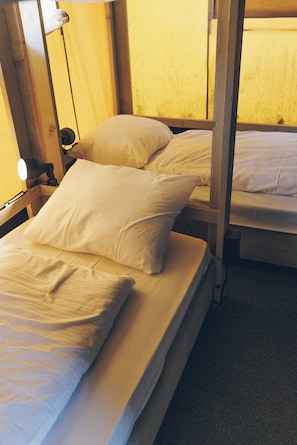 A bunk bed with two pillows and a bedside lamp.