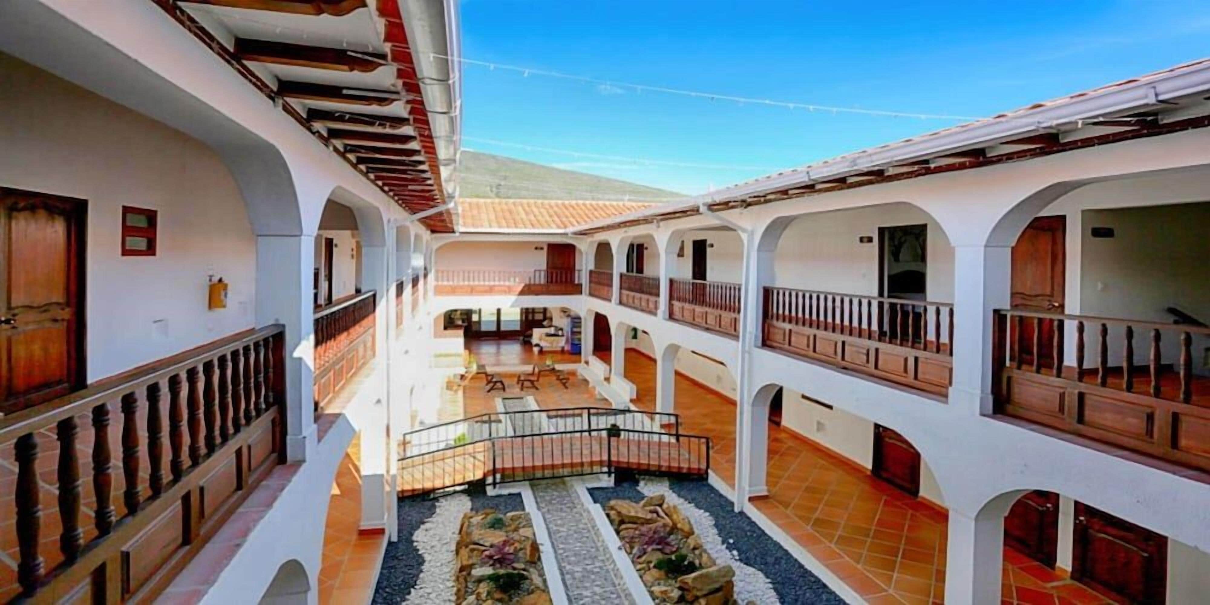A courtyard with multiple balconies, a central seating area, and a tiled floor.